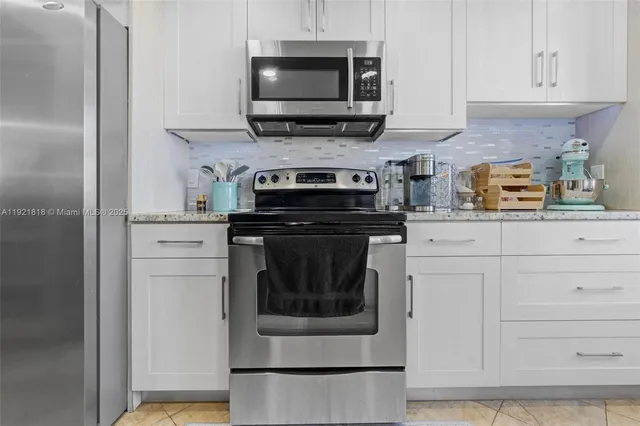 a kitchen with stainless steel appliances granite countertop a stove a microwave and a refrigerator