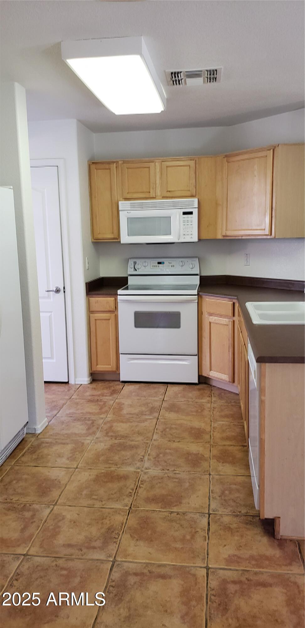 3843 East Derringer Way Gilbert, AZ 85297 - Photo 3 of 13 a kitchen with granite countertop a stove and a sink