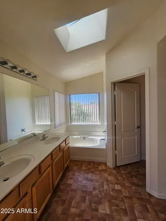 a bathroom with a granite countertop sink and a bathtub