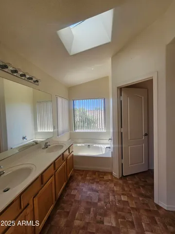 a bathroom with a granite countertop sink and a bathtub