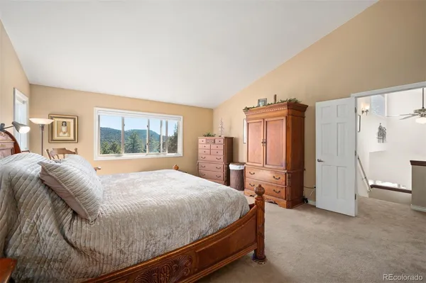 a bed sitting in a spacious bedroom next to a window