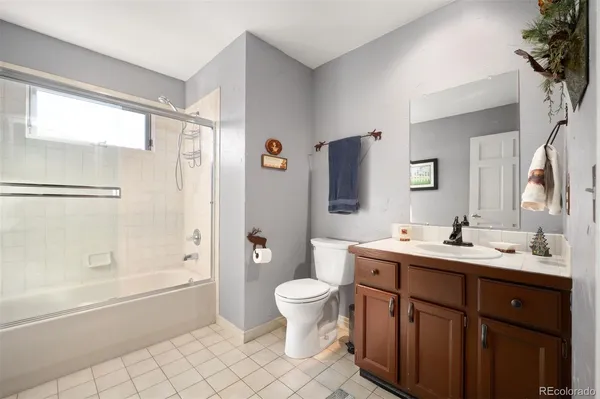 a bathroom with a double vanity sink toilet mirror and shower