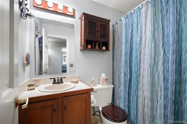 a bathroom with a sink a toilet and a mirror