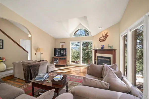 a living room with furniture a large window and a fireplace