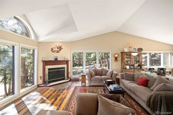 a living room with furniture a large window and a fireplace
