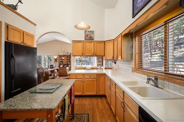 a kitchen with stainless steel appliances granite countertop a sink a stove and a refrigerator