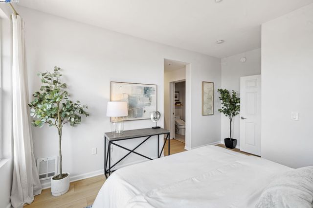 a bedroom with a bed table and a potted plant