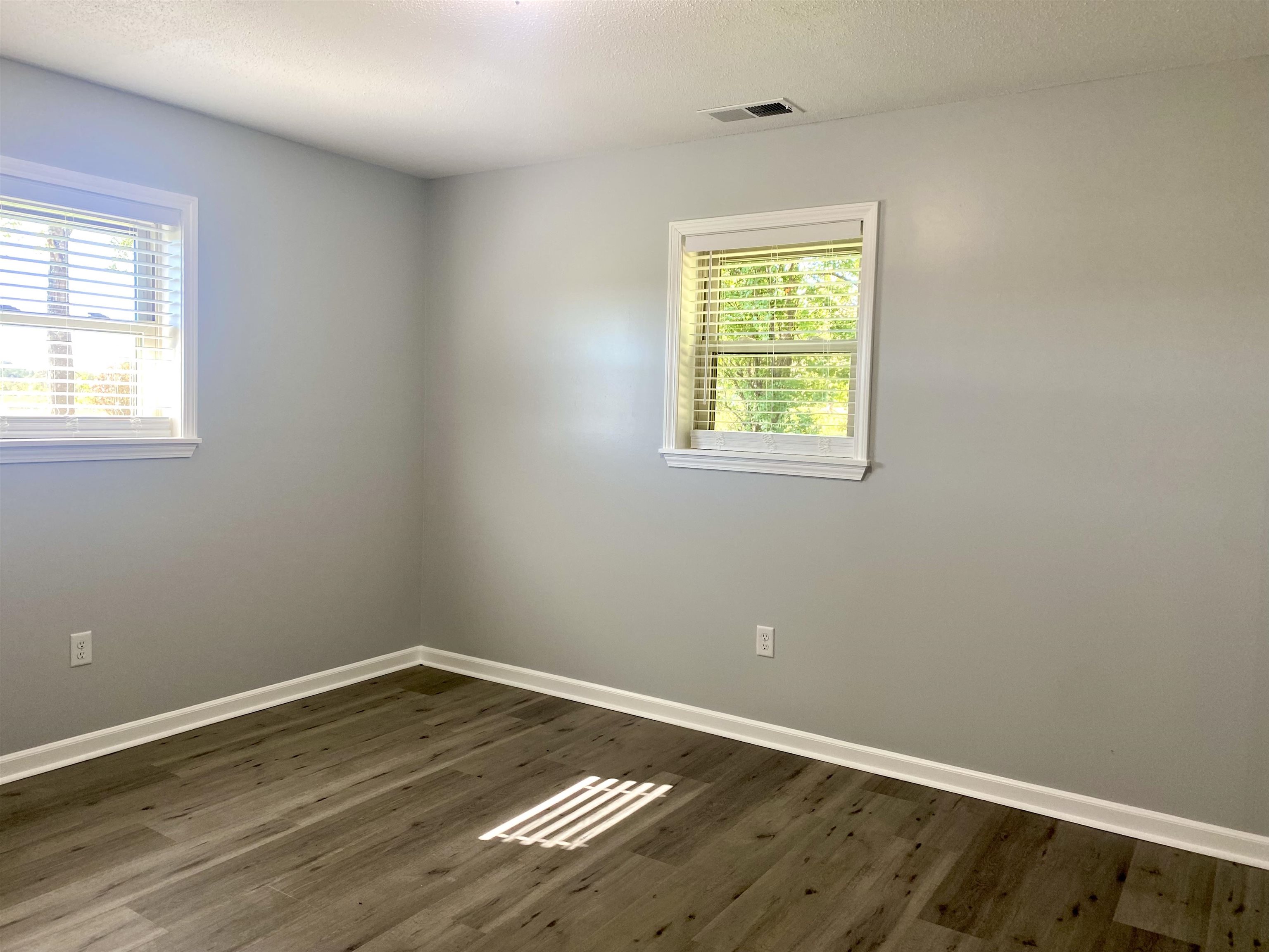 1608 Sam Burlison Road Burlison, TN 38015 - Photo 13 of 25 a view of an empty room with wooden floor and a window
