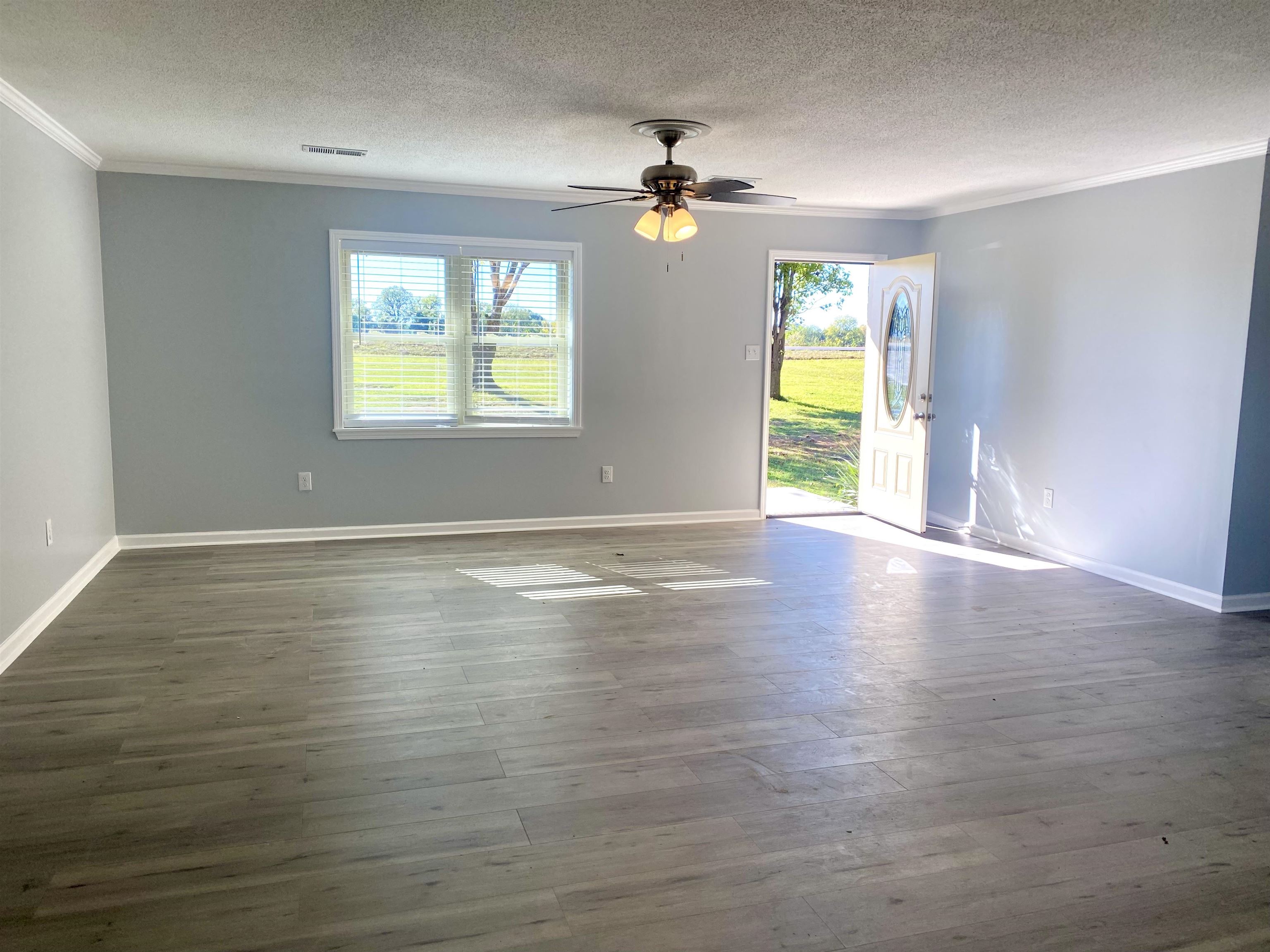 1608 Sam Burlison Road Burlison, TN 38015 - Photo 6 of 25 a view of an empty room with a window and wooden floor