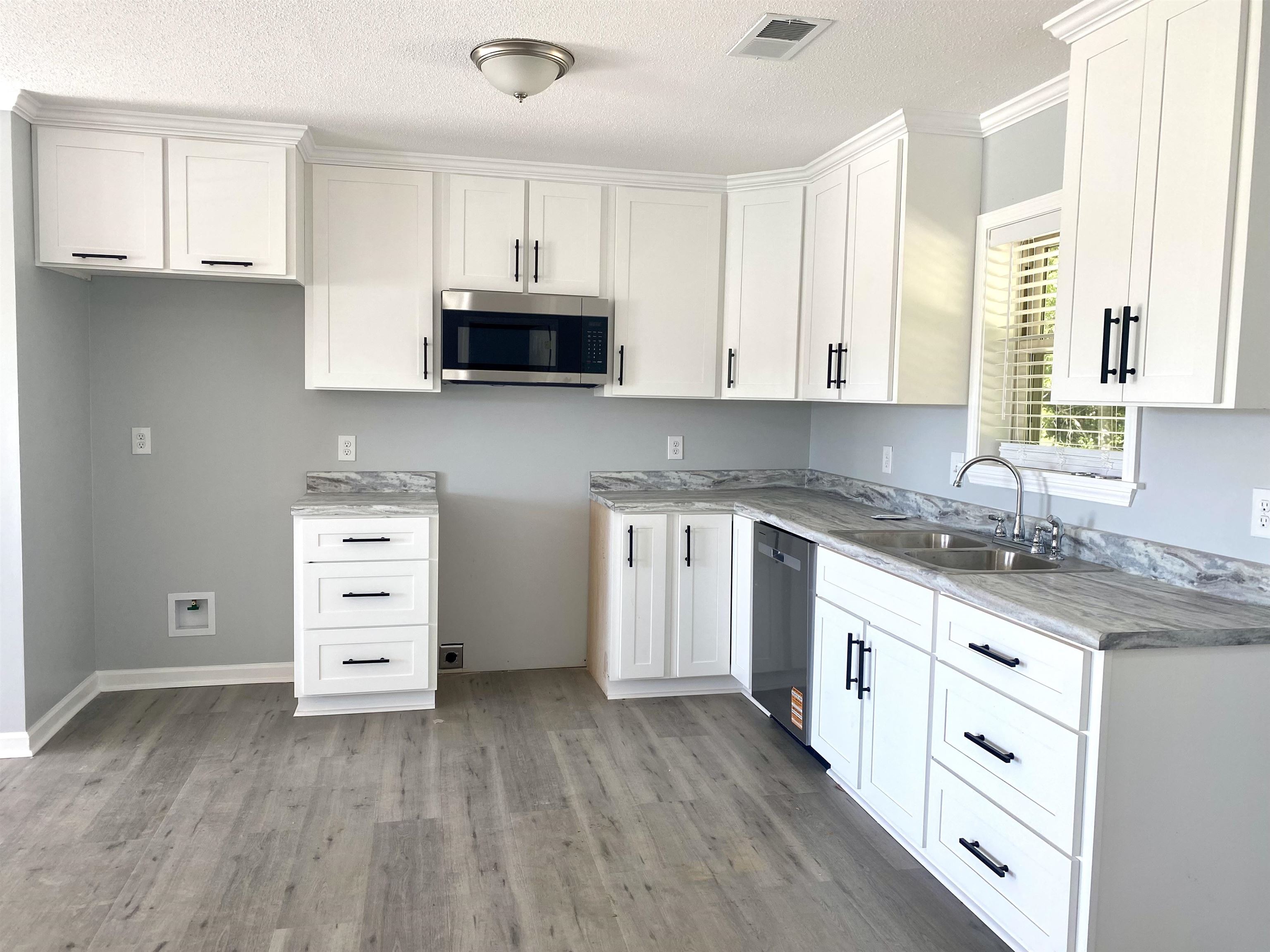 1608 Sam Burlison Road Burlison, TN 38015 - Photo 7 of 25 a kitchen with granite countertop a sink cabinets and stainless steel appliances