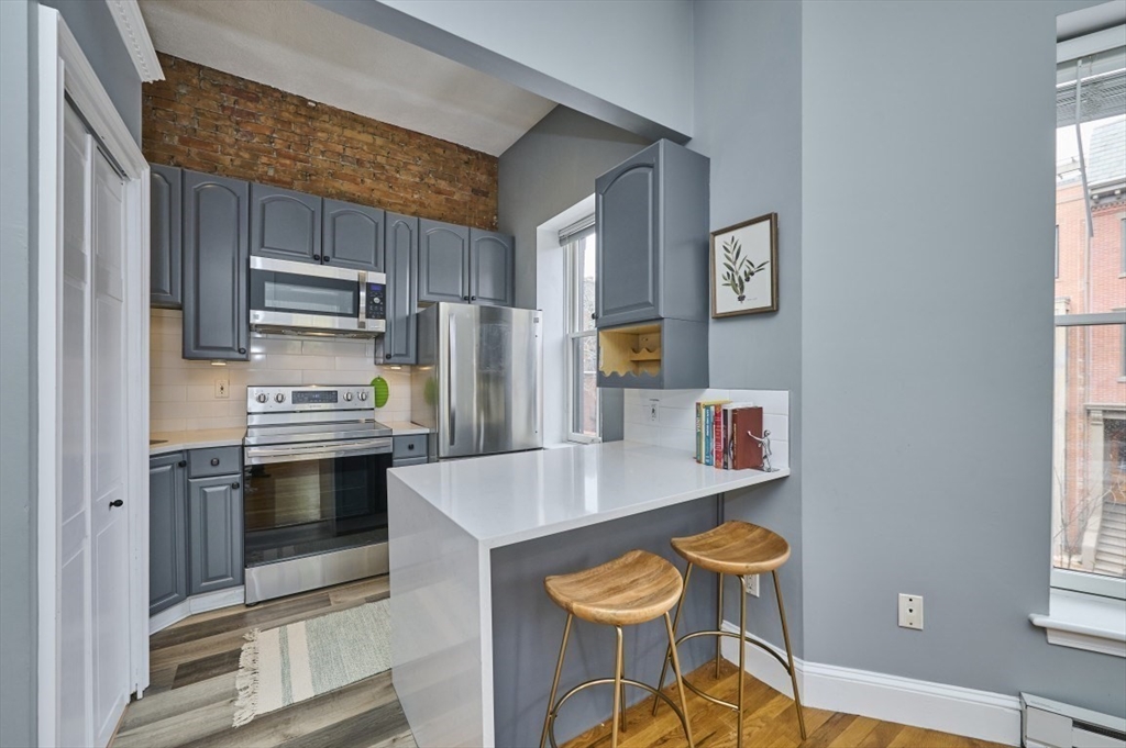 516 Shawmut Avenue, Unit 2 Boston, MA 02118 - Photo 5 of 13 a kitchen with stainless steel appliances a stove a refrigerator and a sink