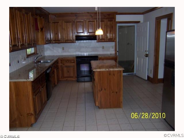 13001 Rivers Bend Road Chester, VA 23836 - Photo 8 of 12 a kitchen with kitchen island granite countertop wooden cabinets a sink and a stove