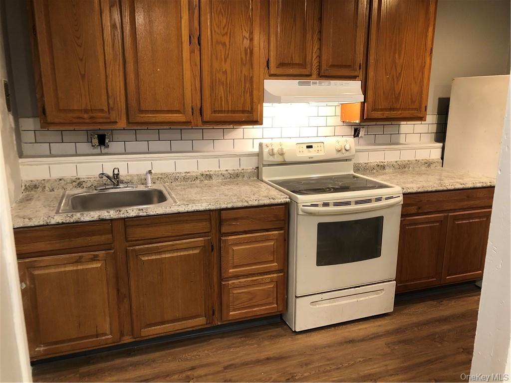 a kitchen with granite countertop wooden cabinets and white appliances
