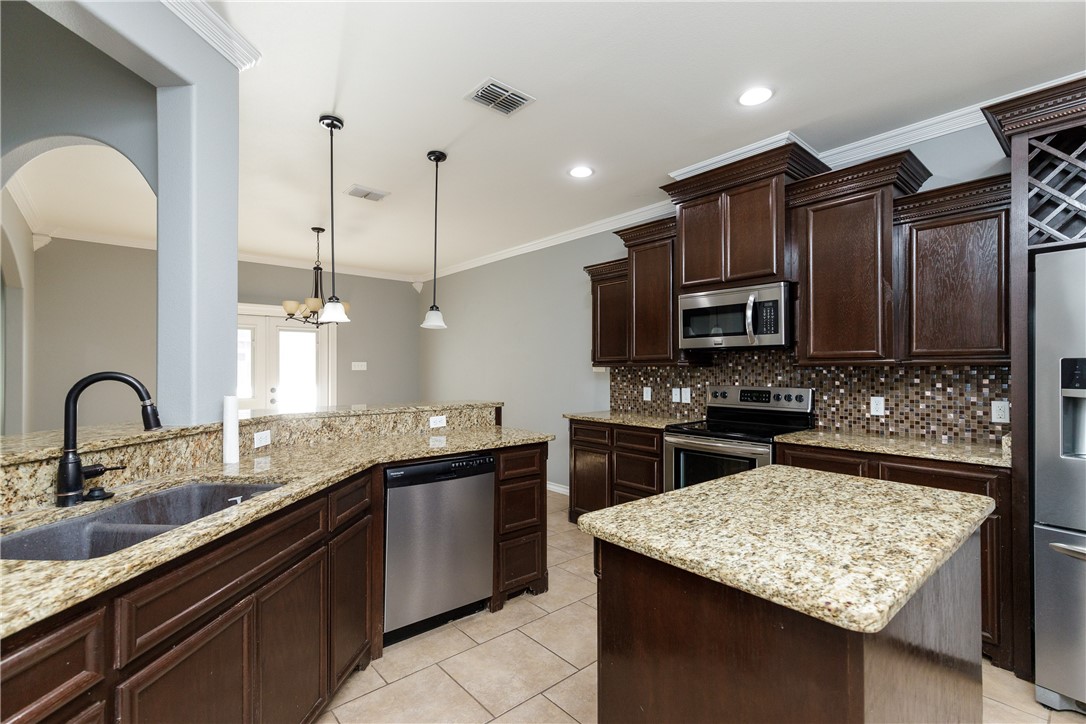 8314 Excalibur Road Corpus Christi, TX 78414 - Photo 10 of 26 a kitchen with stainless steel appliances granite countertop a sink a stove top oven a counter space and cabinets