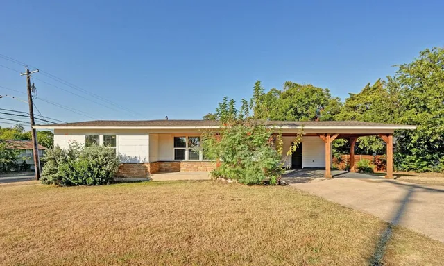 a front view of a house with a yard and potted plants