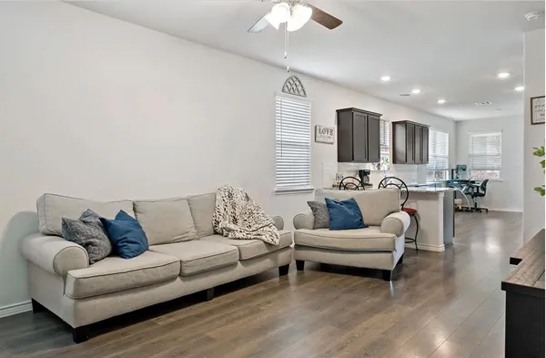 a living room with furniture and a wooden floor
