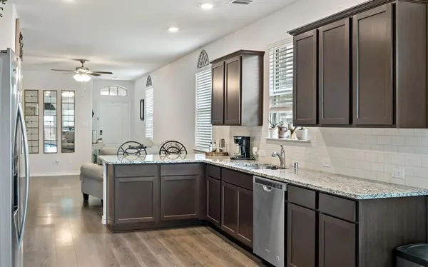 a kitchen with stainless steel appliances granite countertop a sink stove and cabinets