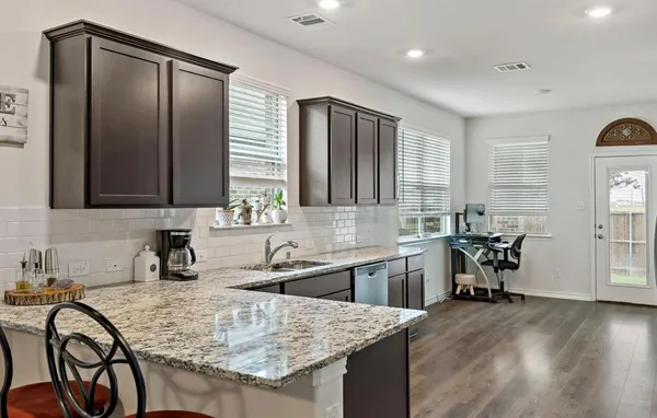a kitchen with a sink a table and chairs