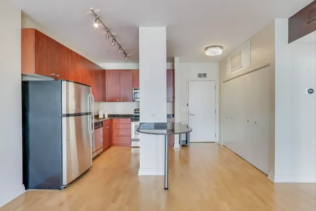 a kitchen with stainless steel appliances a refrigerator and a stove top oven