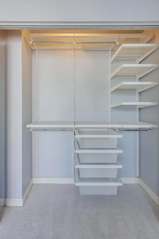 a view of walk in closet with empty racks
