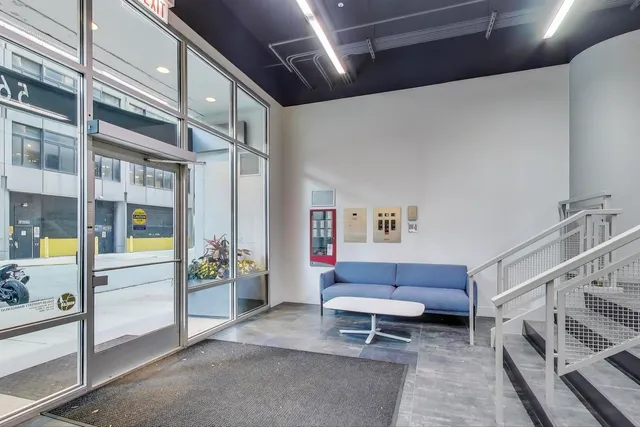 a living room with furniture a rug and white walls