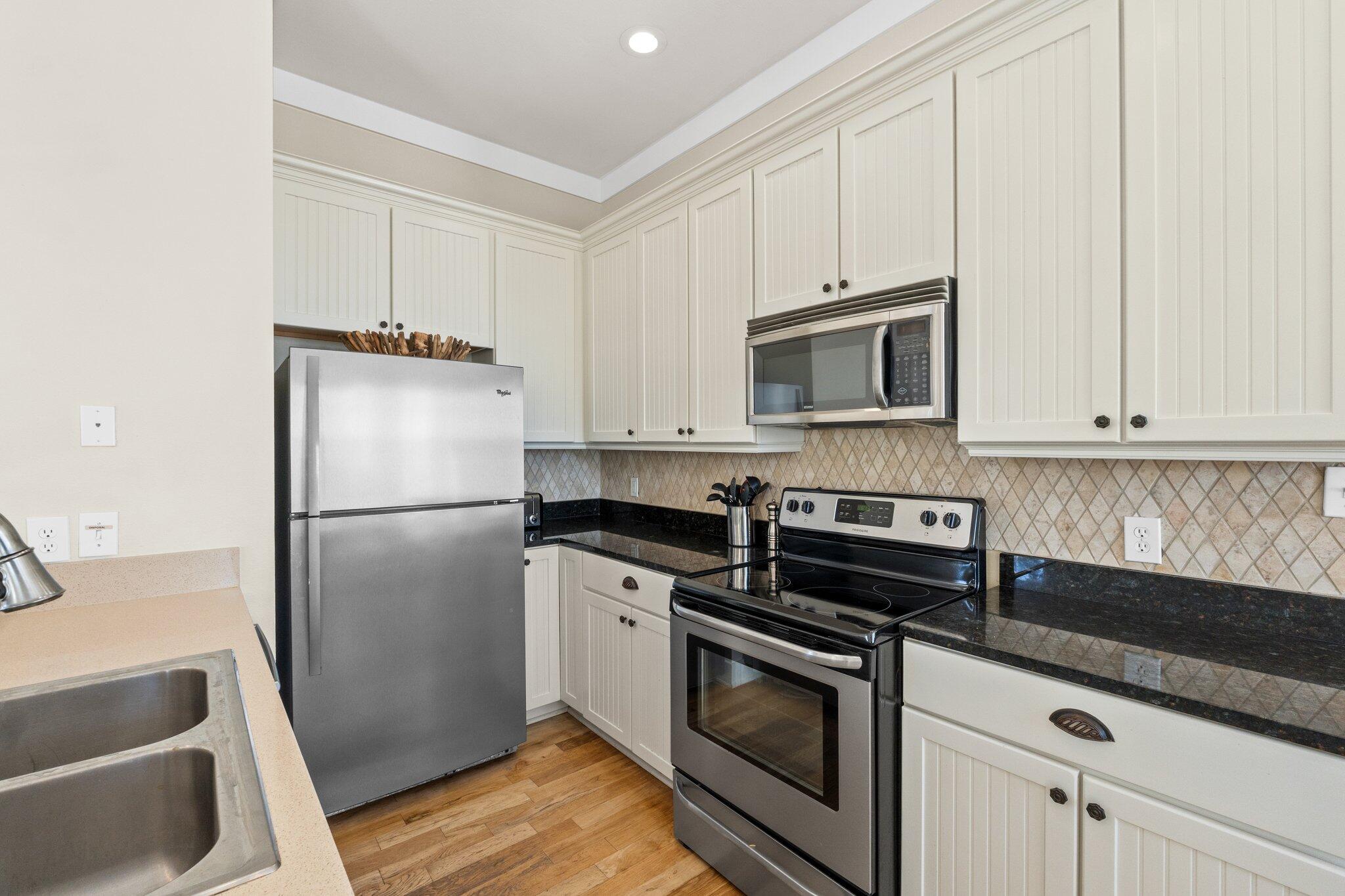 64 Chelsea Loop Road Santa Rosa Beach, FL 32459 - Photo 27 of 57 a kitchen with white cabinets and stainless steel appliances