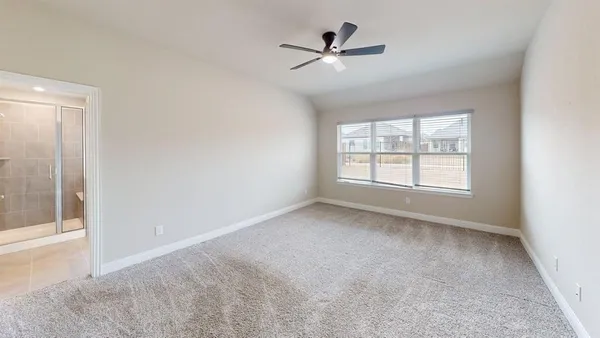 an empty room with windows and fan