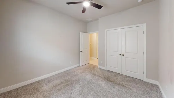 an empty room with a ceiling fan and a window