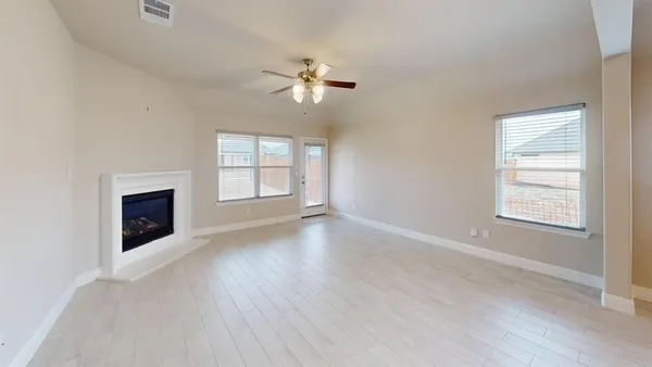 an empty room with windows and fireplace