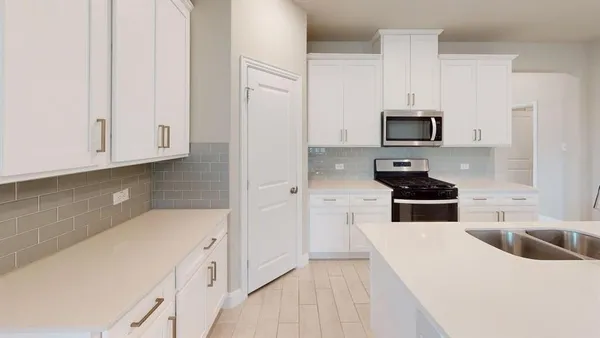 a kitchen with stainless steel appliances a sink a stove a microwave and cabinets
