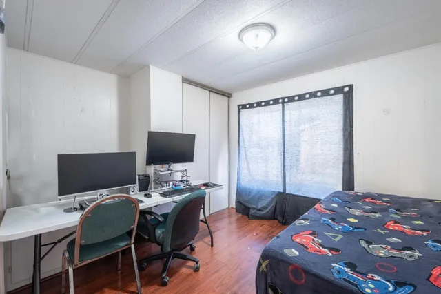 a bedroom with a bed and a wooden floor