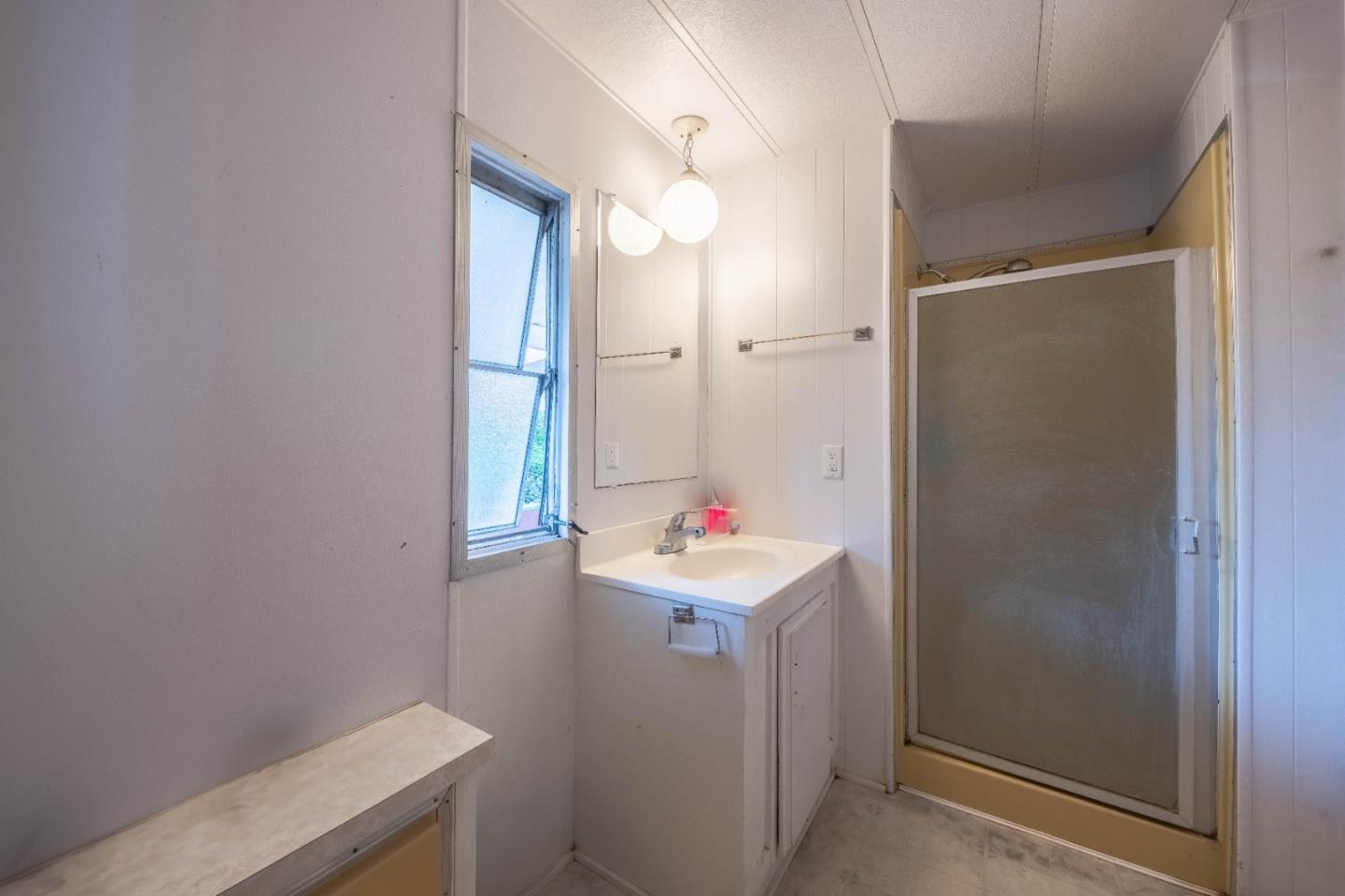 13624 Monte Del Sol, Unit 142 Castroville, CA 95012 - Photo 23 of 25 a bathroom with a sink mirror and a shower