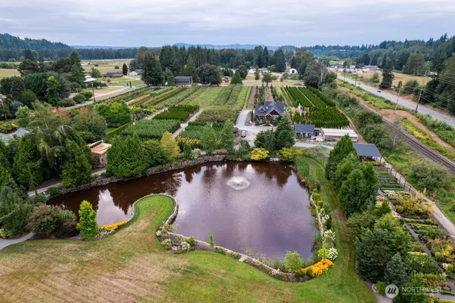an aerial view of a house with a garden and lake view