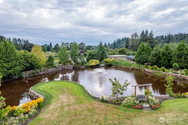 an aerial view of a house with a yard and lake view in back