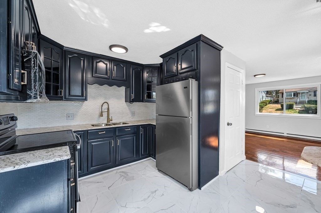 a kitchen with stainless steel appliances granite countertop a refrigerator and a sink
