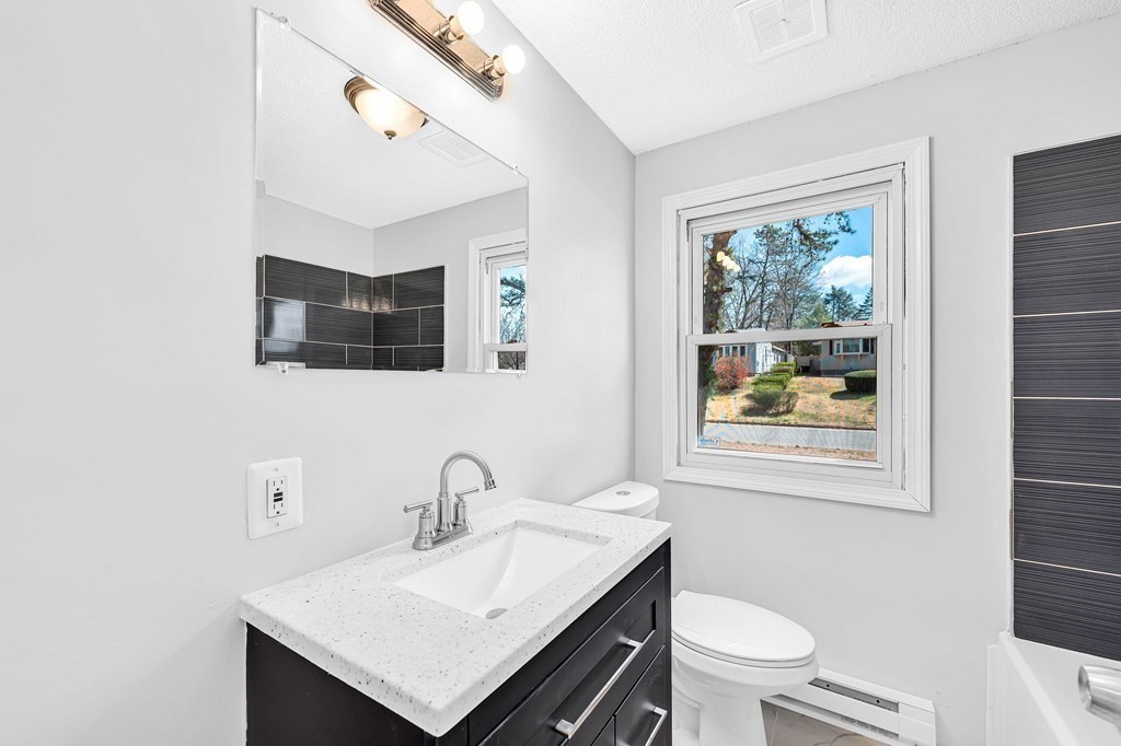 381 North Brook Road Springfield, MA 01119 - Photo 14 of 35 a bathroom with a toilet a sink a mirror and a window