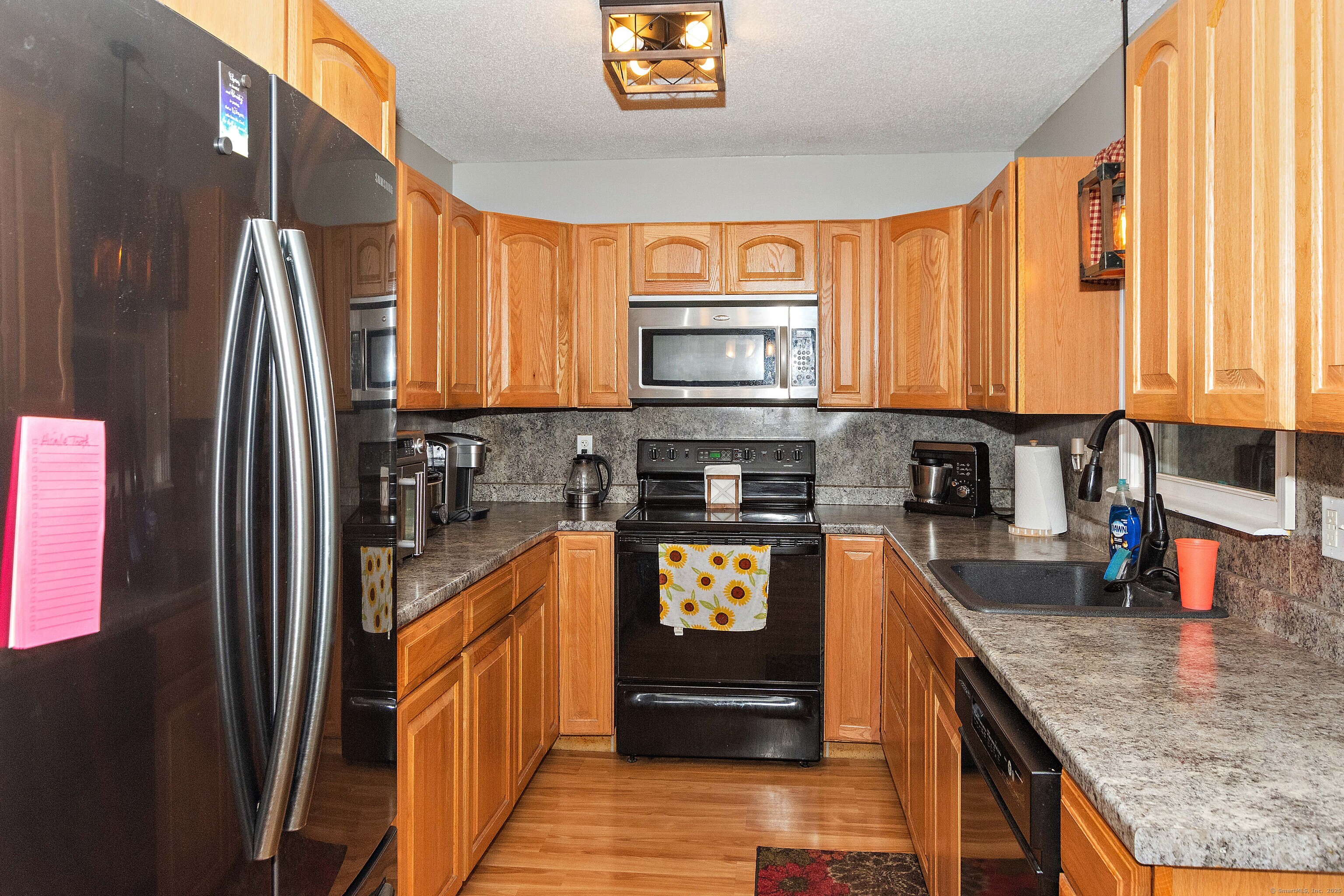 28 Juniper Lane Griswold, CT 06351 - Photo 8 of 15 a kitchen with stainless steel appliances granite countertop a refrigerator a stove top oven a sink and dishwasher
