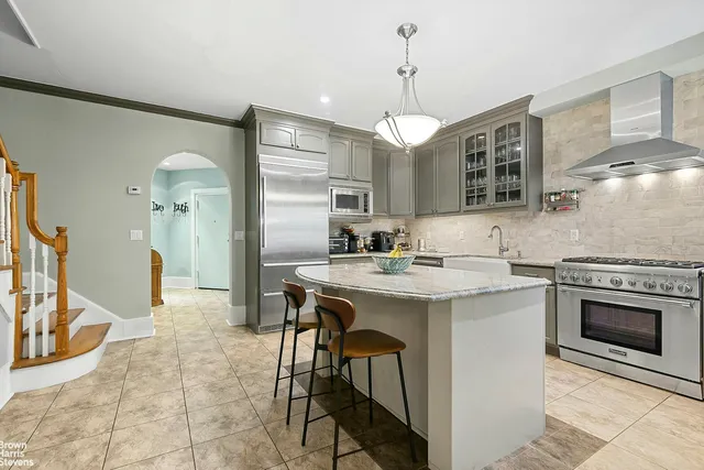 a kitchen with stainless steel appliances granite countertop a sink and a refrigerator