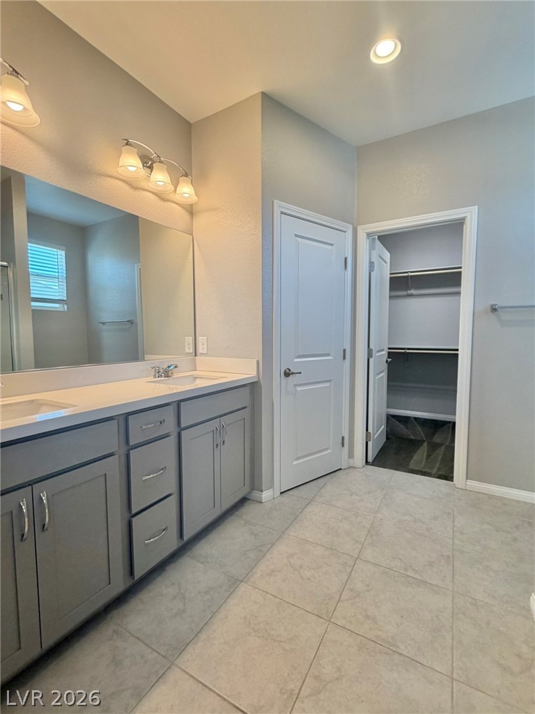 9953 Tucket Point Court Las Vegas, NV 89178 - Photo 17 of 22 A well-appointed primary bathroom features a dual vanity and an adjacent walk-in closet.