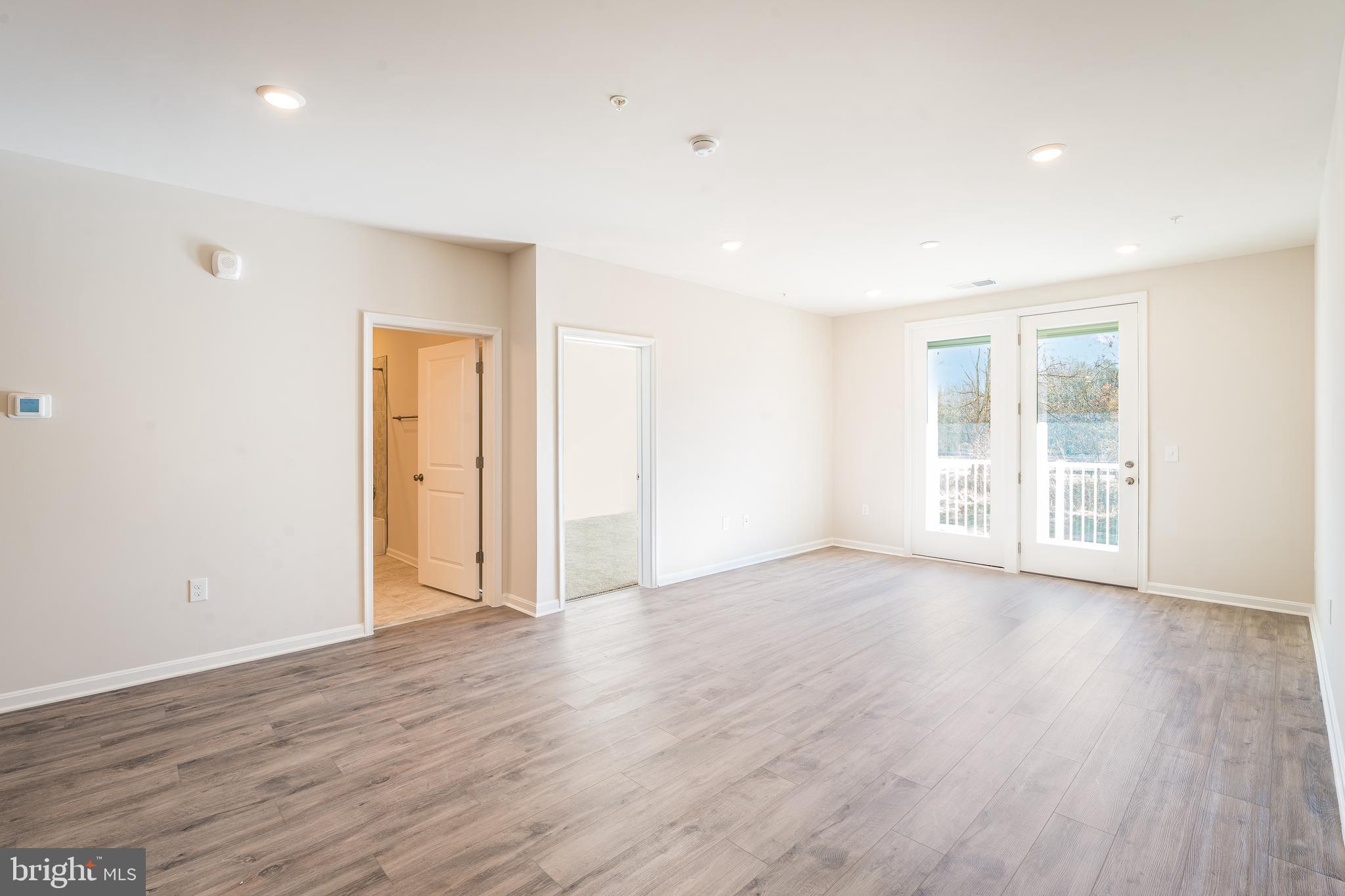 4003 Seaside Alder Road, Unit 409 LILAC Bowie, MD 20720 - Photo 13 of 24 a view of an empty room with wooden floor and a window