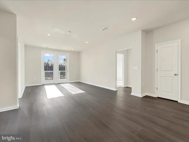 a view of empty room with wooden floor and window