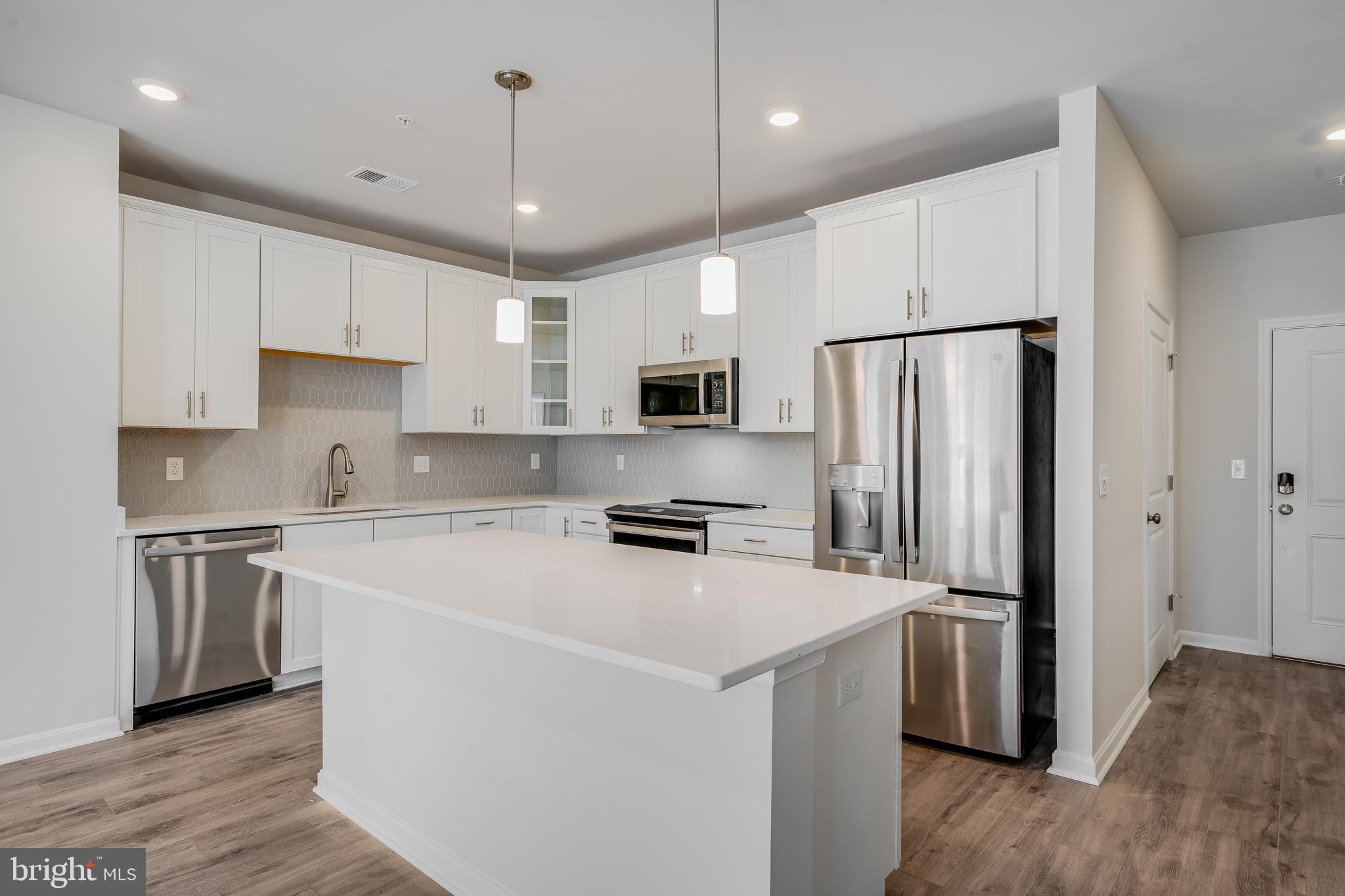 4003 Seaside Alder Road, Unit 409 LILAC Bowie, MD 20720 - Photo 2 of 24 a kitchen with stainless steel appliances a refrigerator stove a sink and white cabinets