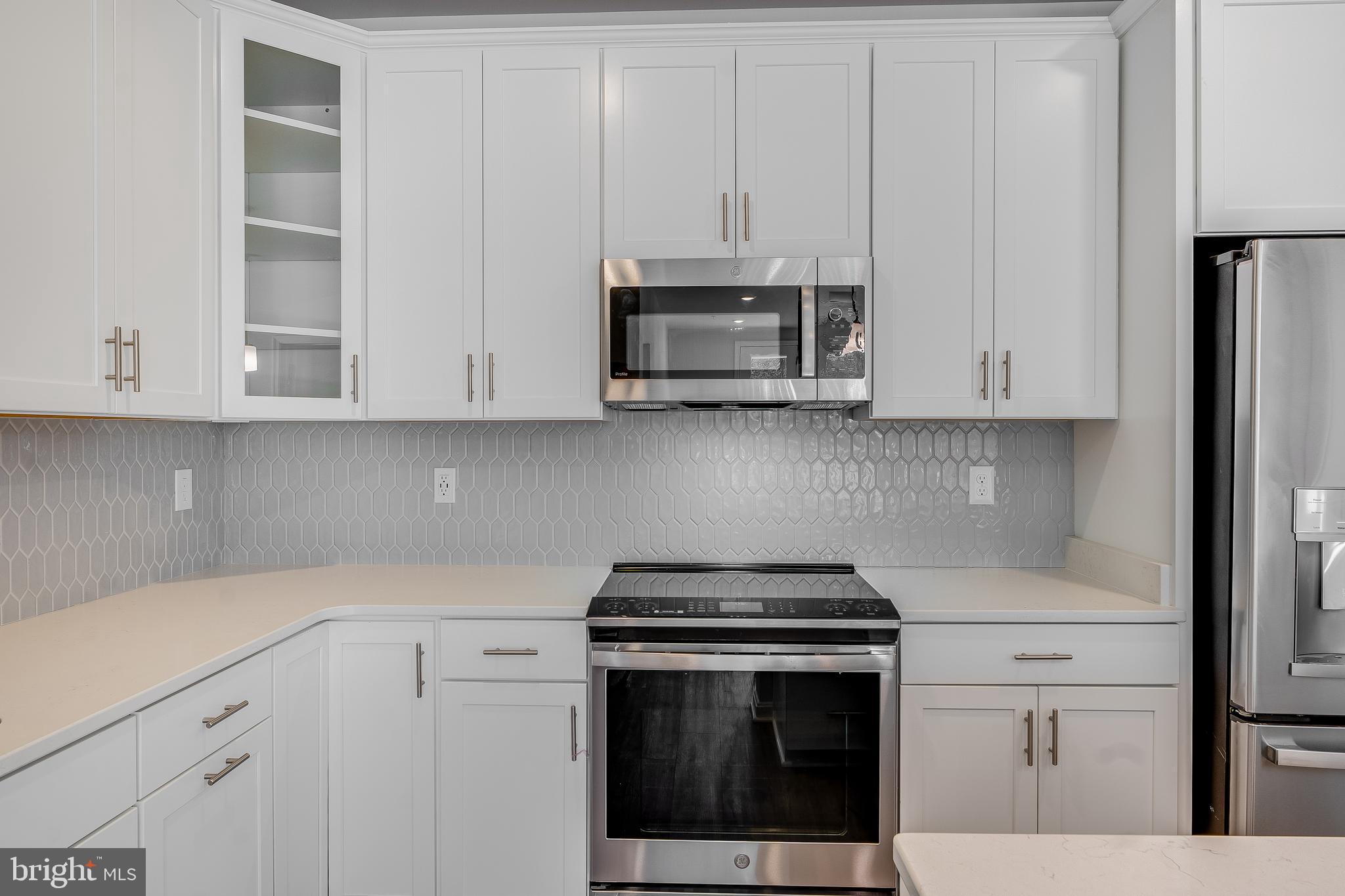 4003 Seaside Alder Road, Unit 409 LILAC Bowie, MD 20720 - Photo 4 of 24 a kitchen with stainless steel appliances granite countertop white cabinets and a stove