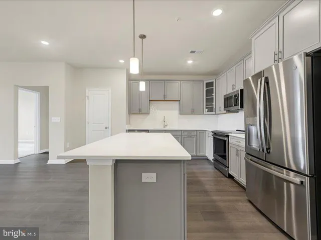 a kitchen with kitchen island a refrigerator stove microwave and cabinets
