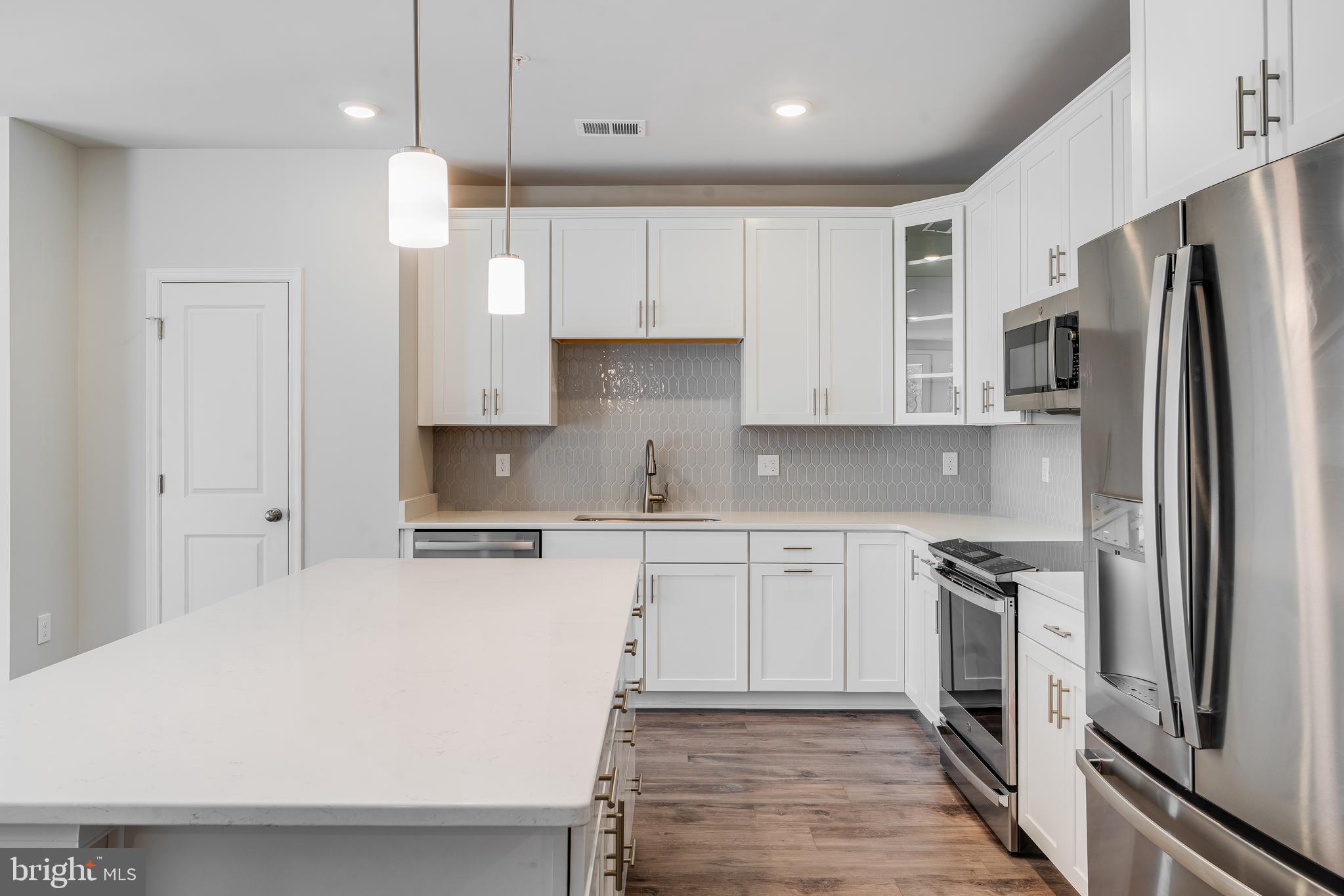 4003 Seaside Alder Road, Unit 409 LILAC Bowie, MD 20720 - Photo 5 of 24 a kitchen with stainless steel appliances a refrigerator sink and stove