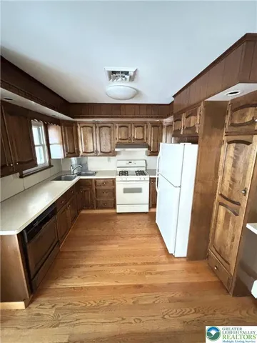 a kitchen with sink refrigerator and cabinets