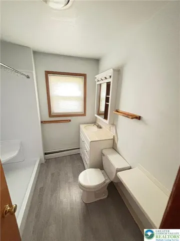 a white toilet sitting next to a bathroom sink and vanity