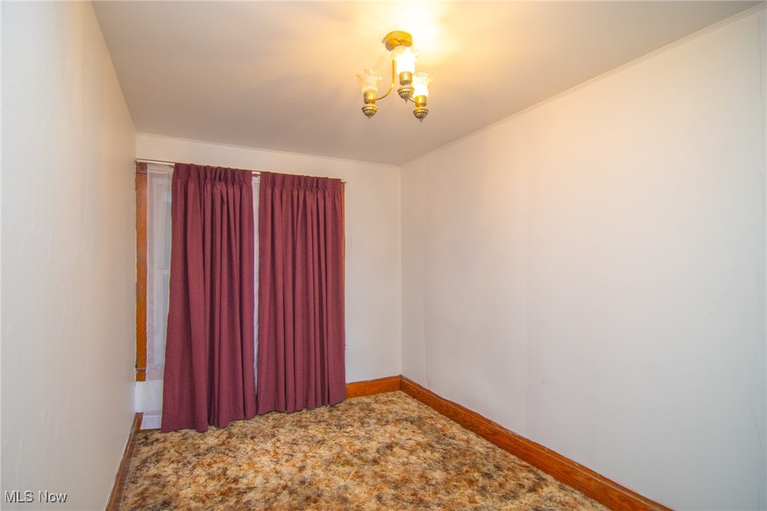 56260 Davis Road Bellaire, OH 43906 - Photo 31 of 44 Empty room featuring an inviting chandelier, carpet, and baseboards