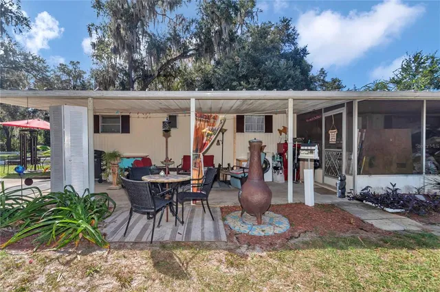 a view of a dinning tables and chairs in backyard of the house