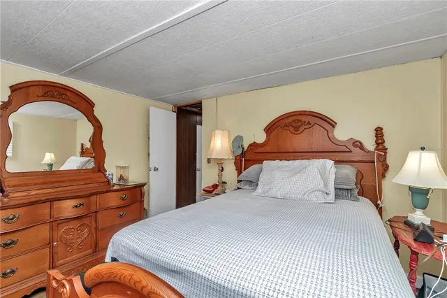 a bedroom with a bed and a dresser with mirror